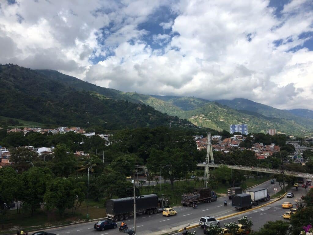 Vue de Piedecuesta entourée de montagnes verdoyantes, avec une avenue urbaine et la cordillère Orientale en arrière-plan
