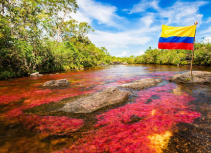 Rivière colorée en Colombie avec le drapeau colombien illustrant la diversité des paysages du pays