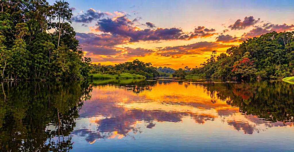 coucher de soleil sur le rio guaviare avec reflets dans l eau et jungle autour de san jose del guaviare en colombie