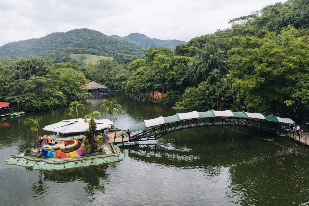 parc naturel à villavicencio avec pont au-dessus d’un lac entouré de végétation tropicale en colombie